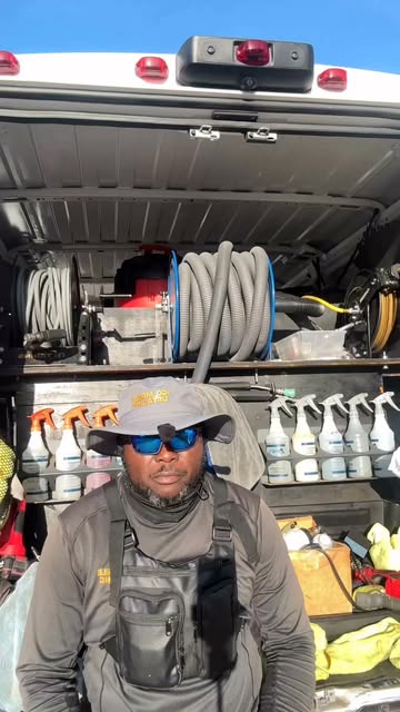 IGO mobile detailer standing in front of organized equipment inside a service van